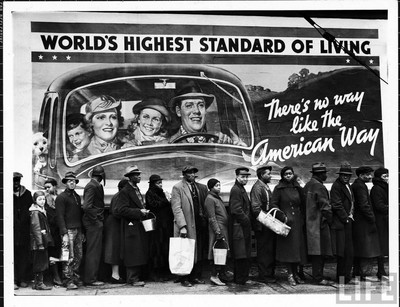 Famous image of African American flood victims lined up to get food & clothing fr. Red Cross relief station in front of billboard ironically extolling WORLD'S HIGHEST STANDARD OF LIVING/ THERE'S NO WAY LIKE THE AMERICAN WAY.  Location: Louisville, KY, US  Date taken: February 1937  Photographer: Margaret Bourke-White
