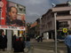 Elezioni per un Kosovo che ancora Stato non è. Manifesto elettorale del partito LDK con alle spalle il comune distrutto dall’incendio – Prizren. 