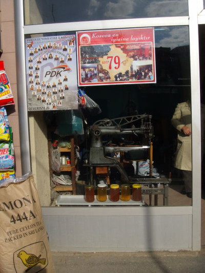 Elezioni per un Kosovo che ancora Stato non è. La bottega di un sarto che vende miele e fa campagna elettorale per il PDK - Prizren. 